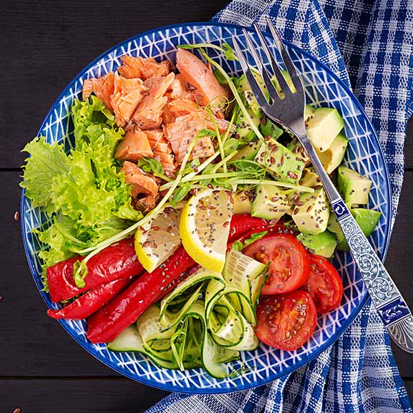 Healthy grilled salmon with avocado, tomato and cucumber — anti-inflammatory meal